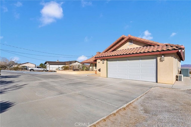 view of property exterior featuring central AC and a garage