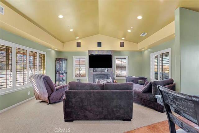 living room featuring vaulted ceiling, a wealth of natural light, and a fireplace