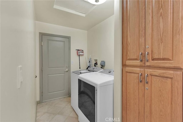 laundry room with separate washer and dryer, cabinets, and light tile patterned floors