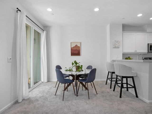 carpeted dining area with sink and plenty of natural light