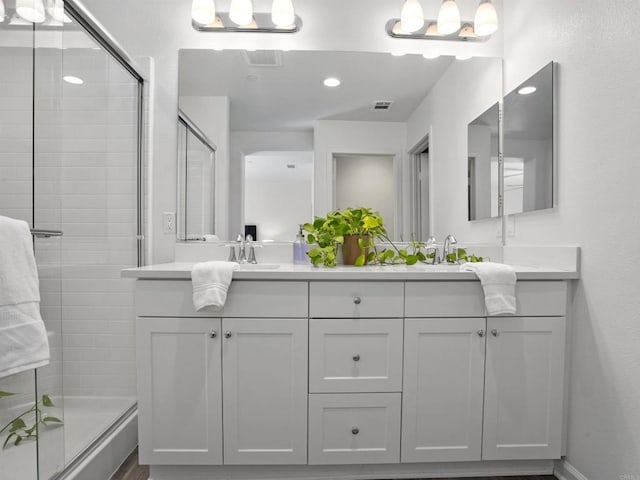 bathroom featuring walk in shower and vanity