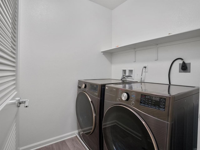 laundry room featuring washing machine and clothes dryer and hardwood / wood-style floors