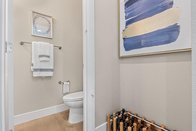 bathroom with toilet and wood-type flooring