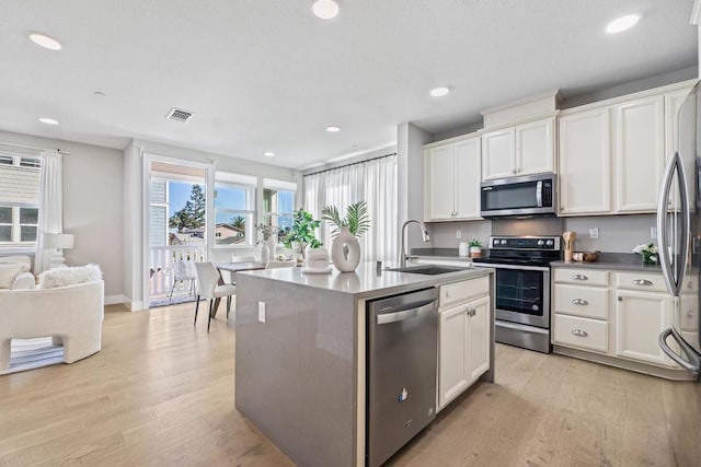 kitchen featuring stainless steel appliances, white cabinetry, and sink