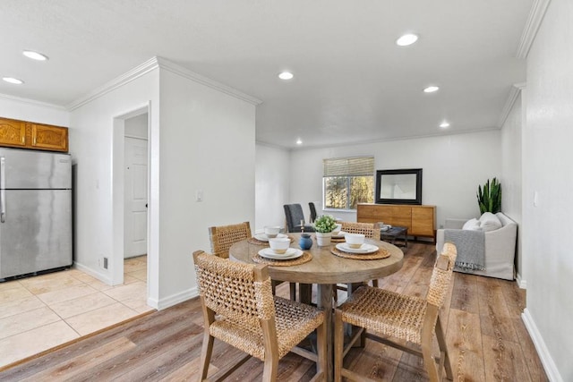 dining space featuring light wood-type flooring and ornamental molding