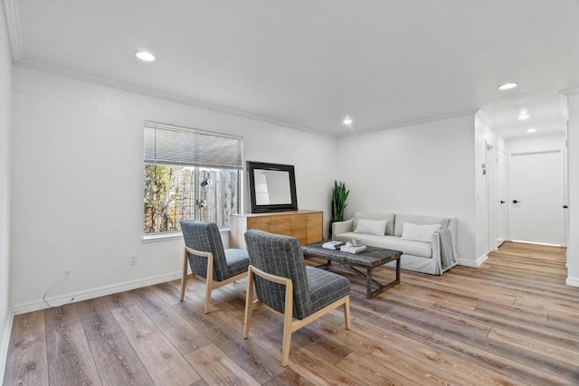 living room with ornamental molding and light hardwood / wood-style floors