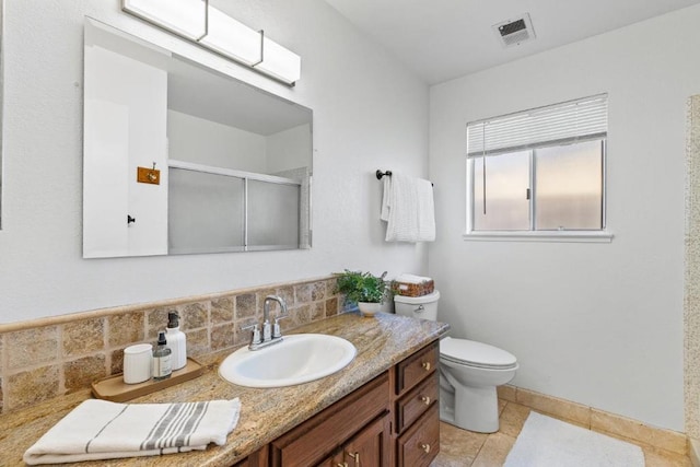 bathroom featuring toilet, tile patterned floors, vanity, and a shower with shower door