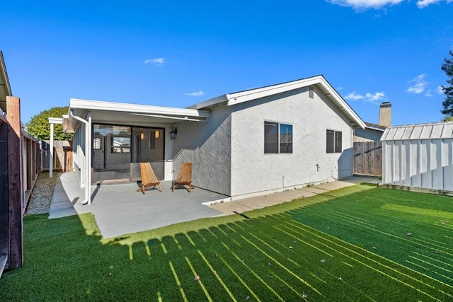 back of property with a lawn and a patio area