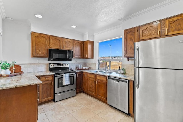 kitchen featuring stainless steel appliances, light tile patterned flooring, a textured ceiling, ornamental molding, and sink