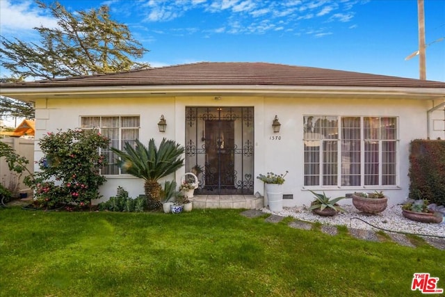 entrance to property featuring a lawn