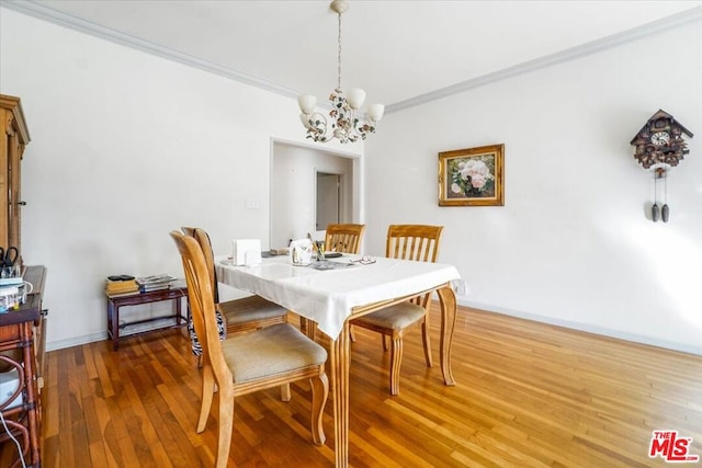 dining space featuring ornamental molding, a notable chandelier, and hardwood / wood-style flooring