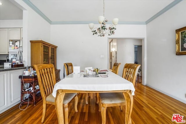 dining area with an inviting chandelier, ornamental molding, and dark hardwood / wood-style floors