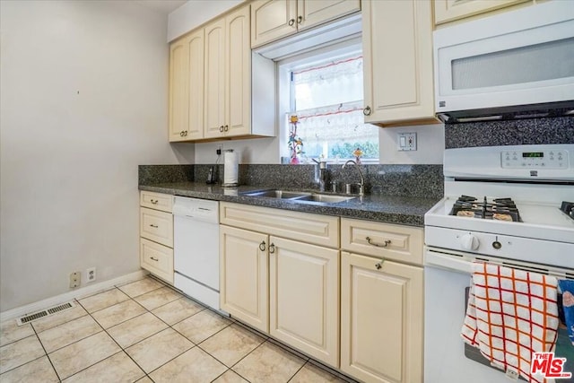 kitchen with white appliances, sink, and light tile patterned floors