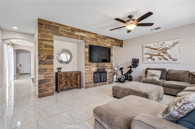 living room featuring ceiling fan and a fireplace