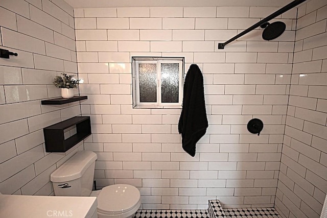 bathroom with vanity, toilet, and a tile shower