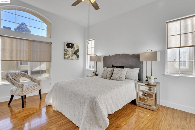 bedroom with ceiling fan, lofted ceiling, and hardwood / wood-style flooring