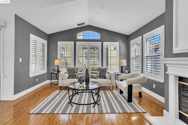 living room featuring light wood-type flooring and vaulted ceiling