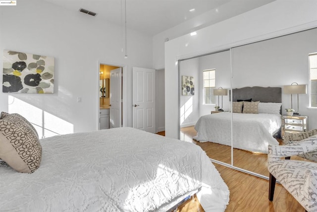 bedroom featuring hardwood / wood-style floors, a closet, and ensuite bathroom