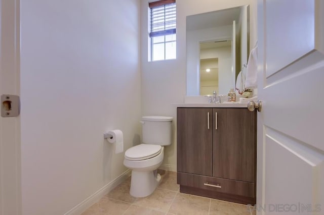 bathroom with toilet, tile patterned floors, and vanity