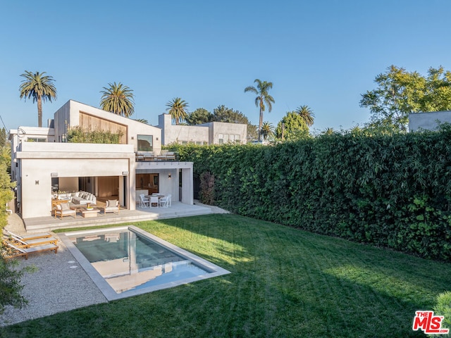 back of property with a patio, a yard, a fenced in pool, and outdoor lounge area