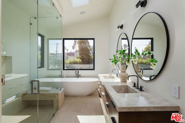 bathroom featuring vanity, lofted ceiling with skylight, and separate shower and tub