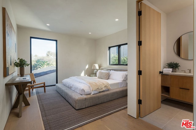 bedroom featuring sink, access to outside, and light hardwood / wood-style flooring