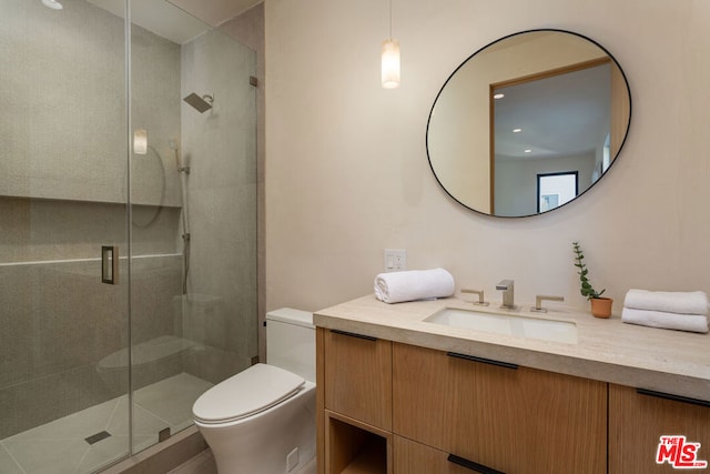 bathroom with toilet, a shower with shower door, and vanity