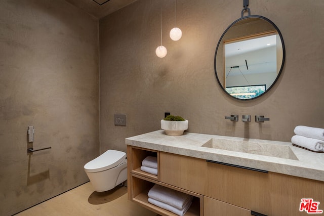 bathroom featuring toilet, hardwood / wood-style flooring, and vanity