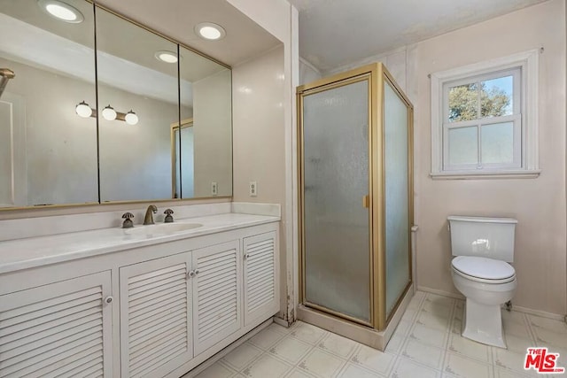 bathroom featuring vanity, a shower with shower door, and toilet