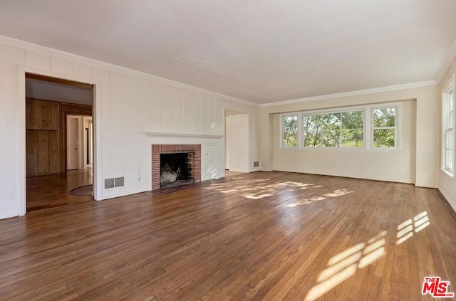 unfurnished living room with a fireplace, crown molding, and dark wood-type flooring