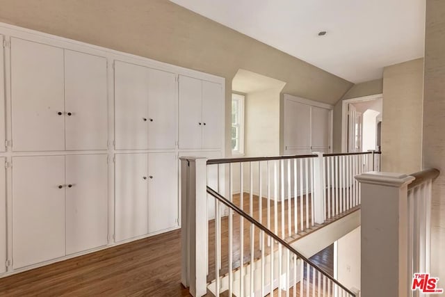 hallway with lofted ceiling and dark hardwood / wood-style floors