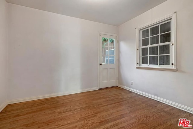 unfurnished room with hardwood / wood-style flooring