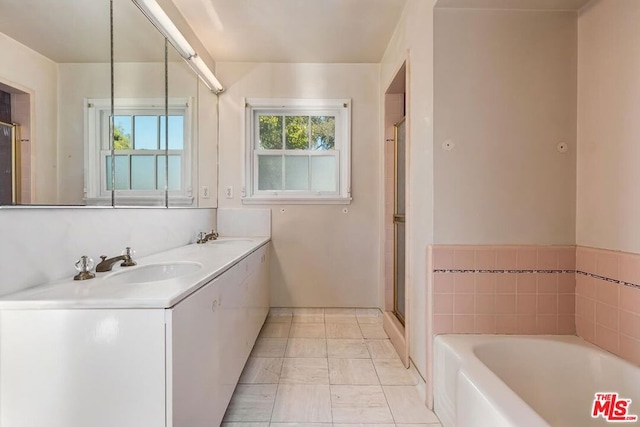 bathroom with vanity, tile patterned floors, a wealth of natural light, and a bathtub