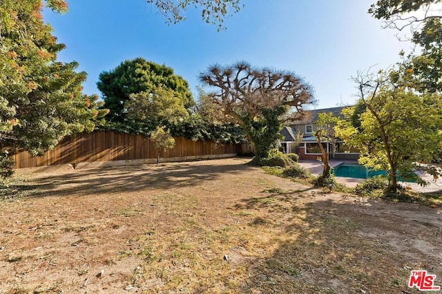 view of yard featuring a patio and a fenced in pool