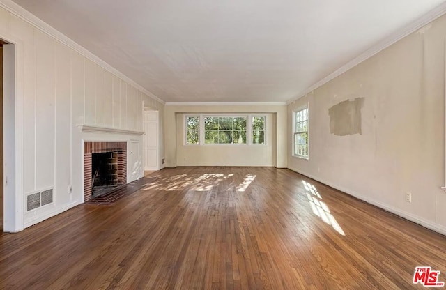 unfurnished living room featuring dark hardwood / wood-style flooring, crown molding, and a fireplace