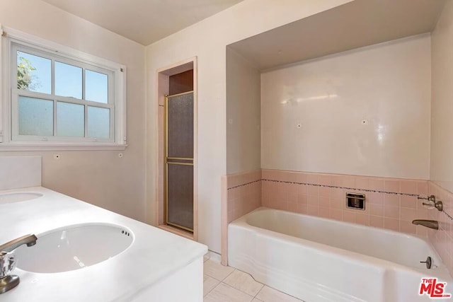 bathroom with a washtub, tile patterned flooring, and vanity