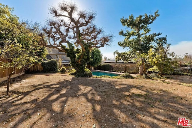 view of yard with a fenced in pool