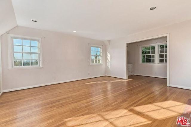 unfurnished room featuring light hardwood / wood-style flooring and vaulted ceiling