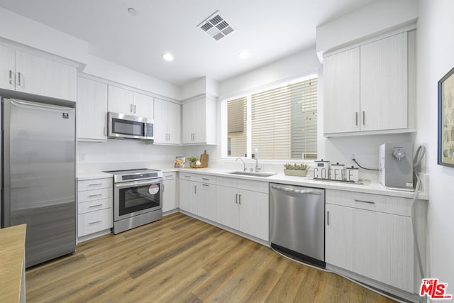 kitchen with sink, white cabinetry, dark hardwood / wood-style floors, and appliances with stainless steel finishes