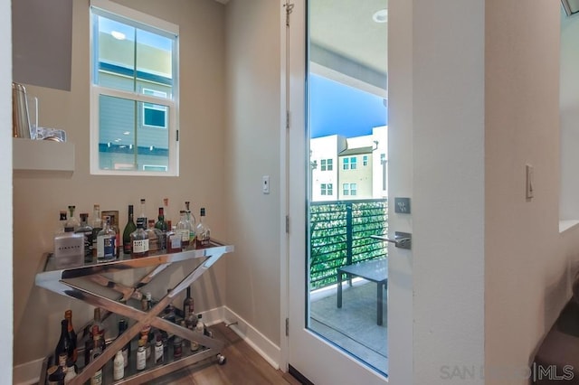 bar featuring hardwood / wood-style floors and plenty of natural light