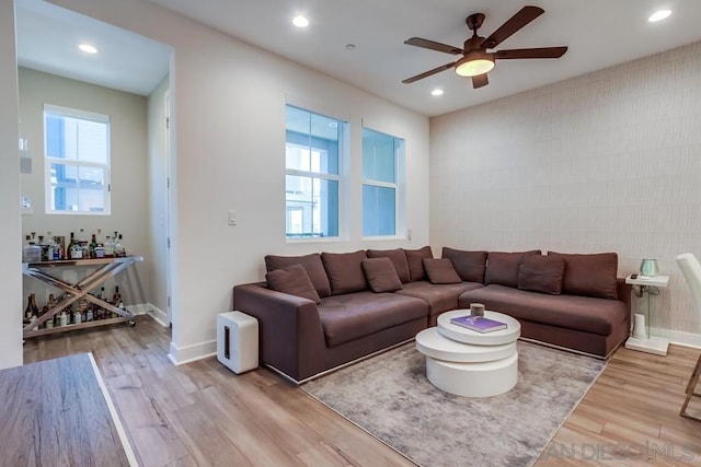 living room with ceiling fan, light hardwood / wood-style floors, and a healthy amount of sunlight