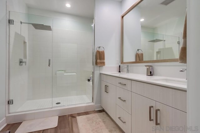 bathroom featuring a shower with shower door, vanity, and wood-type flooring