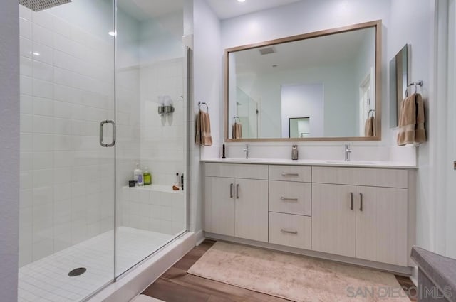 bathroom with a shower with door and vanity