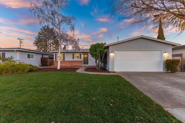 ranch-style house with a garage and a yard