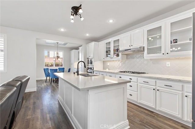 kitchen featuring sink, white cabinetry, a kitchen island with sink, and hanging light fixtures