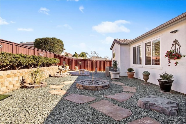 view of yard with cooling unit, an outdoor fire pit, and a patio