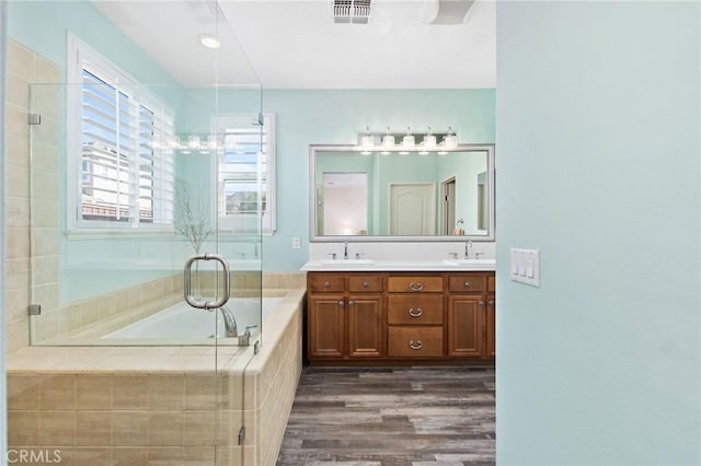 bathroom featuring vanity, hardwood / wood-style flooring, and shower with separate bathtub