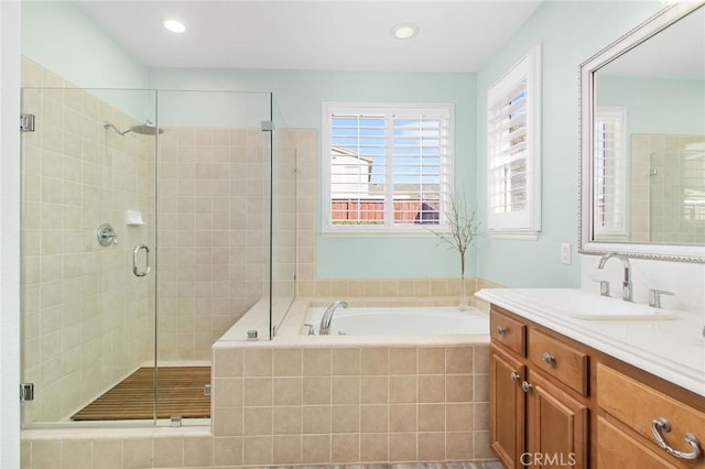 bathroom featuring shower with separate bathtub and vanity