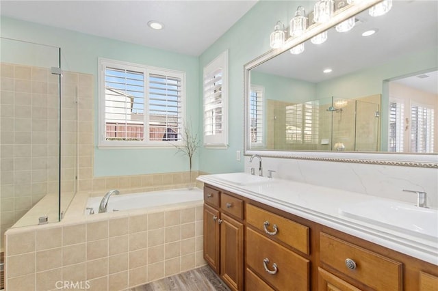 bathroom featuring plus walk in shower, wood-type flooring, and vanity