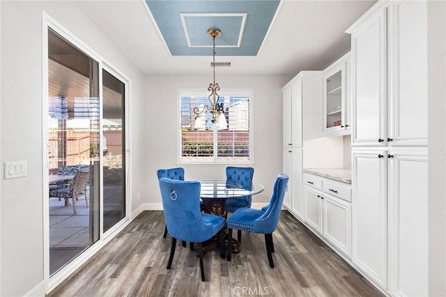 dining area with dark hardwood / wood-style floors and a notable chandelier